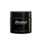 Hemlock Hair Paste 2 oz matte medium-hold styling paste jar, front label with Hemlock Grooming Supply logo